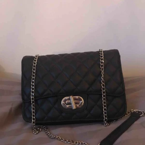  - Superfin svart väska från Nelly, är lite mjukare i modellen. Passar både till vardags och fest.