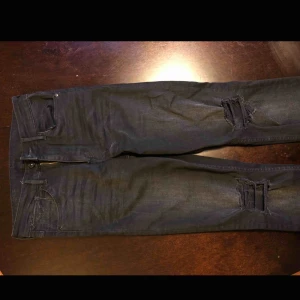  - Nästan helt oanvända jeans från H&M med snygga slitningsdetaljer. Höga i midjan och stuprörsben.