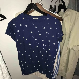  - Marinblå t-shirt med vita blommor från Pull & Bear, säljs då den inte kommer till användning längre. Frakt tillkommer!