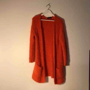  - Härligt mjuk kofta med en knallig orange färg. Nyskick! Endast använd en gång! 