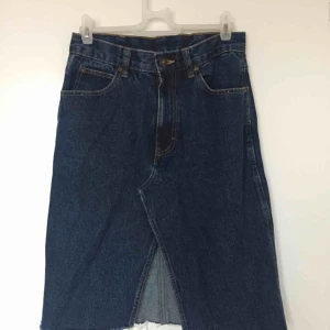  - Jeanskjol vintage inköpt på Beyond Retro. Fint skick. Hög midja, går ner till knäna (på mig som är ca 170), slits framtill. Superskön och snygg.