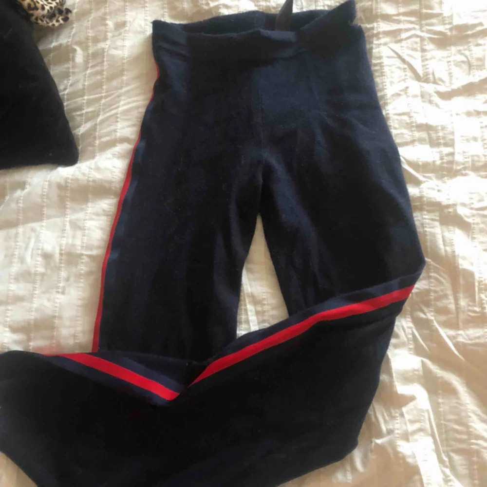 Mörkblåa mjukis byxor med röda ”linjer”, slits längst ned på benet ( bild 2 ). Skit häftiga, använd fåtal ggr. Jeans & Byxor.