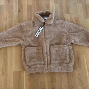  - En nyköpt och oanvänd Pixie Coat i färgen Caramel. Den är i storlek XS men är oerhört oversized så den passar även dig som bär S eller M.  Jag köpte den från webbsidan i.am.gia för 1500kr (inkl. Tull).