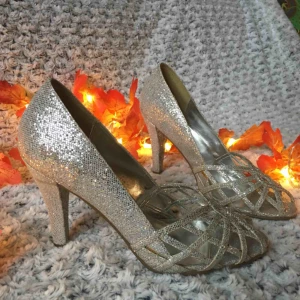  - Glittriga silverpumps från Harrods i London. Perfekta till nyår, eller när som helst du känner för att glittra lite xtra! Mkt sparsamt använda, men fått lite missfärgning på några ställen (se bild) som dock bara syns om man kollar nära. Nypris ca 1000kr. 