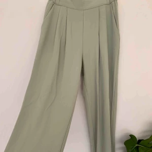  - Ljusgröna (?) kostymbyxor med fickor och något utsvängda ben. Färgen är mer blågrön irl. Knappt använda! Möts upp i Göteborg eller skickar mot frakt! 