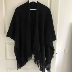  - Fin svart poncho från Åhléns som tyvärr inte kommer till användning. Använd fåtal gånger så i väldigt fint skick. Katt finns i hemmet! Frakt betalas av köparen. 