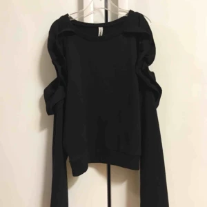  - Snygg svart tröja med volang och öppna axlar! Oanvänd.