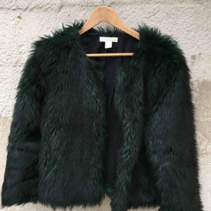  - Väldigt bra skick, ser oanvänd ut. Färgen skiftar mellan mörkgrön till svart.  Varm och skön nu till hösten!  Storlek 36. Men passar även dig som har storlek 38. Längd 52 cm.  Ärm: 66 cm. Frakten är inräknad i priset. 