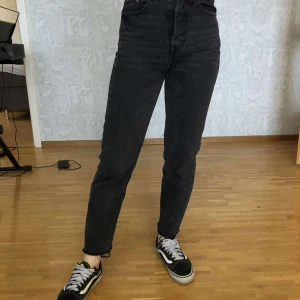 Svarta mom-jeans - Säljer dessa mom-jeans i en urtvättad svart färg. Storlek 32, tror byxorna är korta i modellen då personen på bilderna är 163cm. Kan fraktas :)