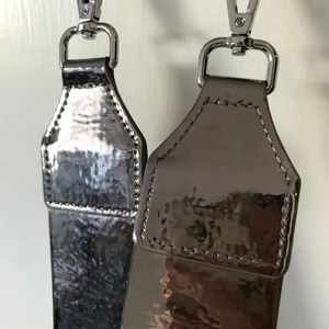 Väskrem  - En bred väskrem med i skimrande material! från carin wester! accepterar bud!