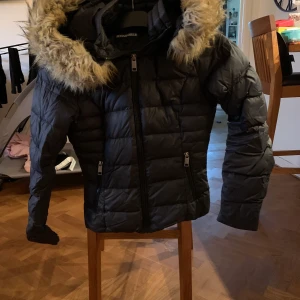 Rockandblue dunjacka  - En äkta dunjacka från rockandblue i strl 32. (Liten i storleken). Fint använt skick. Köptes förra året för ca 2400kr men där är en liten reva på armen som är lagad hos sömmerska så de syns knappt så därför säljer ja den för 600kr. 63kr för spårbar frakt tillkommer 