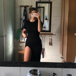 Klänning med split - Fin klänning från boohoo med stretch. Längre klänning med split på ena sidan, frakt ingår