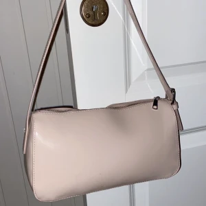 Ljusrosa väska - Superfin väska som tyvärr inte används längre, den är i ett blankt material som är skitsnyggt. Säljer för 150kr och då ingår frakten💞
