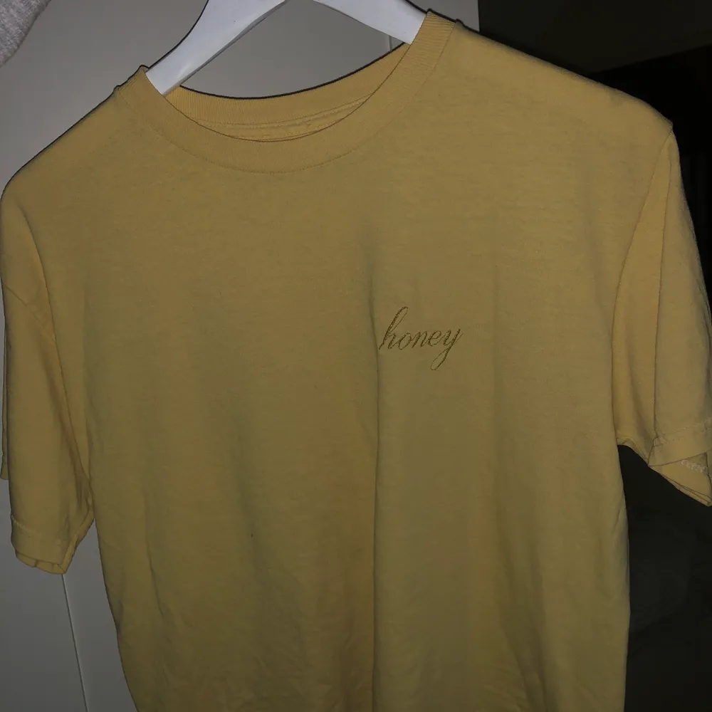 Gul T-Shirt från Brandy Melville. Använt den Max 4 gånger då den inte riktigt är min stil. Det står ”honey” på vänstra sidan. Jättehärlig gul färg! . Skjortor.