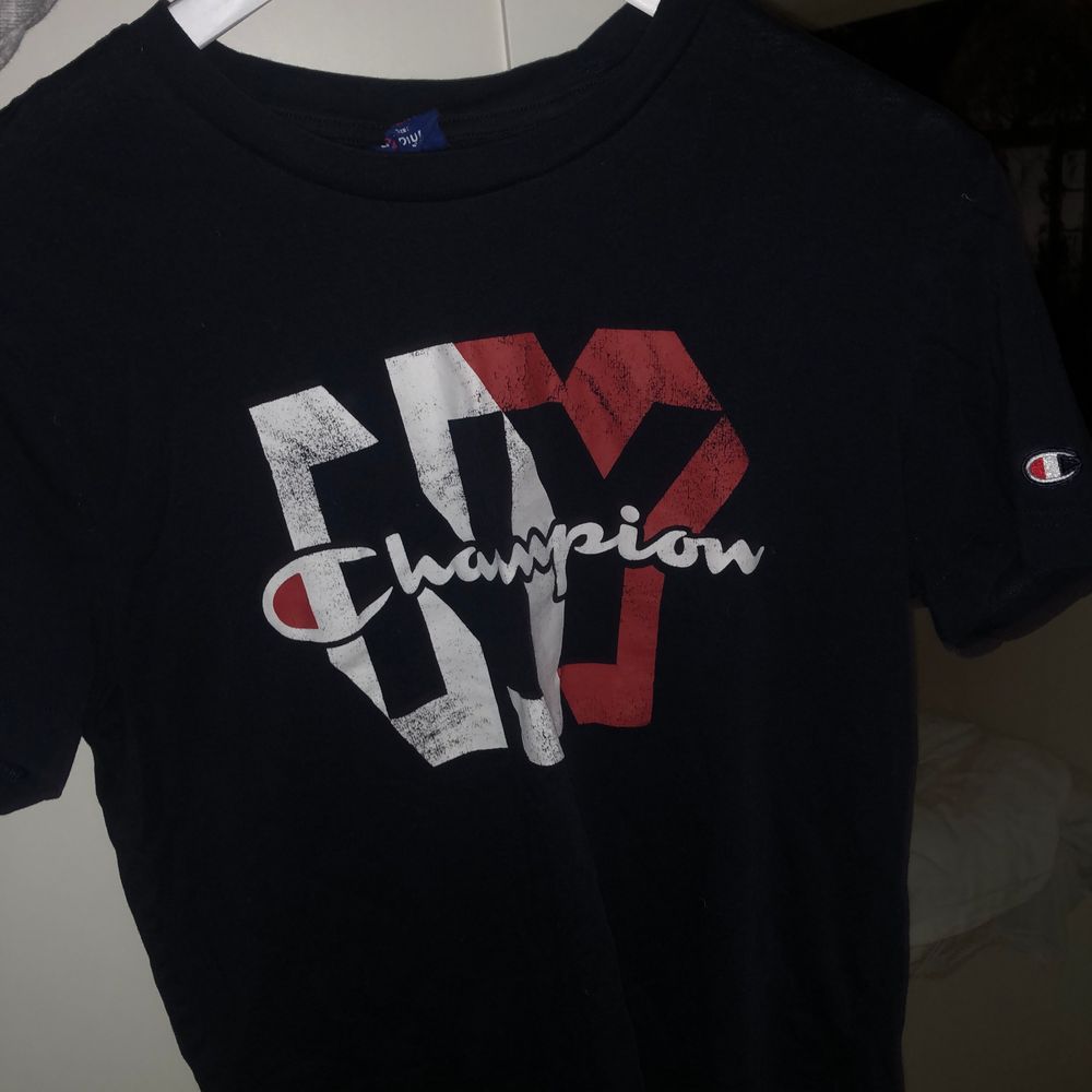 Navy blå (mörk blå) T-shirt från Champion. Köptes från Stadium förra året. Den är inte i dåligt skick utan det är så den var köpt- modellen antar jag ska vara lite ”vintage”.. Skjortor.