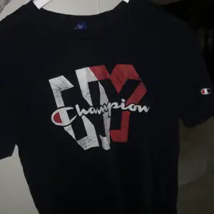 Navy blå (mörk blå) T-shirt från Champion. Köptes från Stadium förra året. Den är inte i dåligt skick utan det är så den var köpt- modellen antar jag ska vara lite ”vintage”.