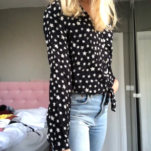Blus/topp från Zara st S - Blus med stjärnor på från zara. Har en knytning vid nederkanten av tröjan och använd Max 2 gånger. Skriv vid intresse!