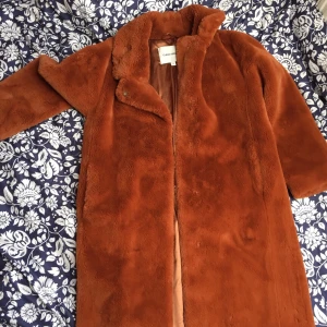 Carin Wester fejkpäls - Höstpäls (fejk) från Carin Wester. Superfin rävröd färg. Mjuk, gosig och varm. Silkesfoder. Innerficka. Jag mäter 163 cm, då slutar pälsen strax under knät. Använd 2 ggr, så är precis som ny! Nypris: 1000kr. Säljes: 500kr. Upphämtning Malmö