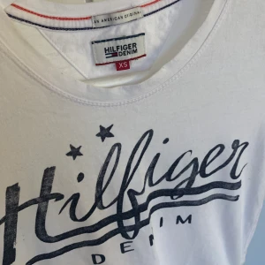 T-shirt Hilfiger - Säljer denna snygga T-shirt från Tommy Hilfiger då den inte kommer till användning.. strl xs. Fint skick! Pris + frakt.