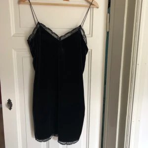 Sammetsklänning med spets  - Kort sommarklänning i sammet som ser svart ut men skiftar i mörkblå i ljus, och med svart spets. Medium. 150kr. 