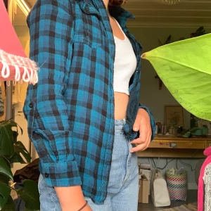 Flanell skjorta - Skjorta med vanliga knappar, längre där bak än fram och har knappar så man kan vika upp ärmarna. I väldigt fint skick! 50kr+frakt