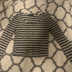 Ribbad tröja - Ribbad tröja från New Yorker svart, vit, grå och rosa randig. Knappar.