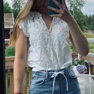Vit blus - Fin kortärmad blus med knappar och broderade spetsdetaljer i stl. L. Jag är vanligtvis en stl. 36, men beror ju på hur man vill att den ska sitta. Skrynklig, men stryker innan jag postar!😽 Köpt på Vero Moda. Betalning sker via swish. 50kr+frakt!🥰