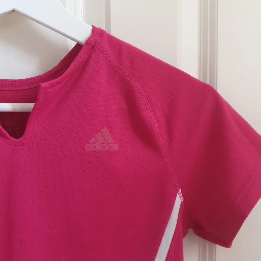 Rosa träningströja med vita linjer längs sidorna. Adidas syns men har suddats ut något. Några noppror och dragna maskor på framsidan vilket sänker priset. Hör av dig vid frågor💕🌸. Hoodies.