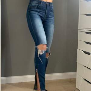 Jättesköna snygga blåa jeans med hål i knäna och dragkedja längst ner på benen! Sitter bra med hög midja samtdigit som det går att få en rakare look genom att öppna dragkedjorna. (Frakt inräknat i priset)