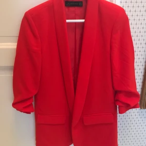 Kavaj röd - Röd kavaj från Chiquelle, ca 1 år använd men ser ut som ny. Har sömmar i armarna så den ser ”uppkavlad” ut. 