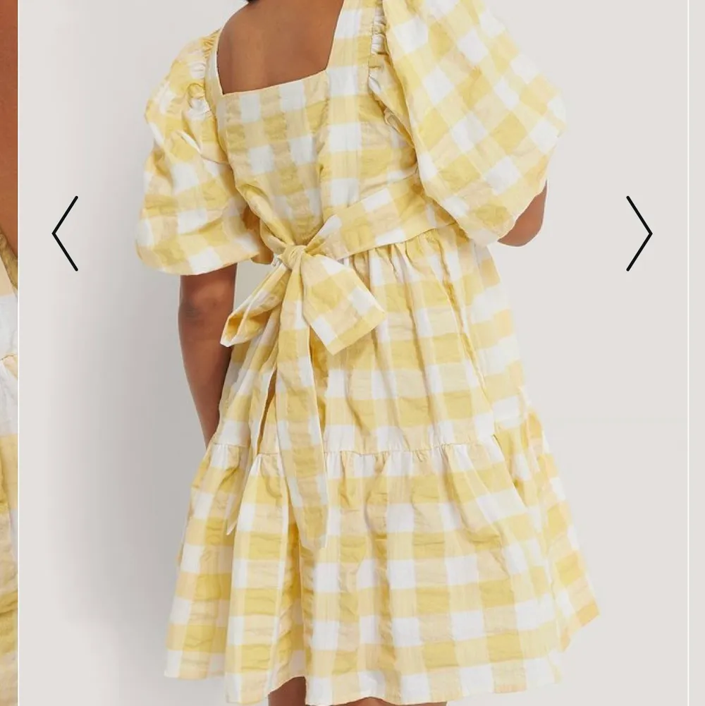 En gul rutig klänning med puffärm, helt ny med lapp kvar. Köpt för 599 kr. Köparen står för frakt . Klänningar.