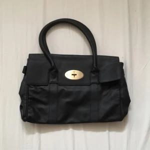  - Helt oanvänd Mulberryväska (ej äkta). Knoppar på undersidan (bild 3). Mellanstor. 