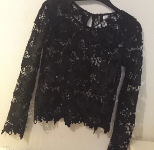  - Svart "virkad" blommig topp. Fin att ha som den är eller med ett svart linne under!

