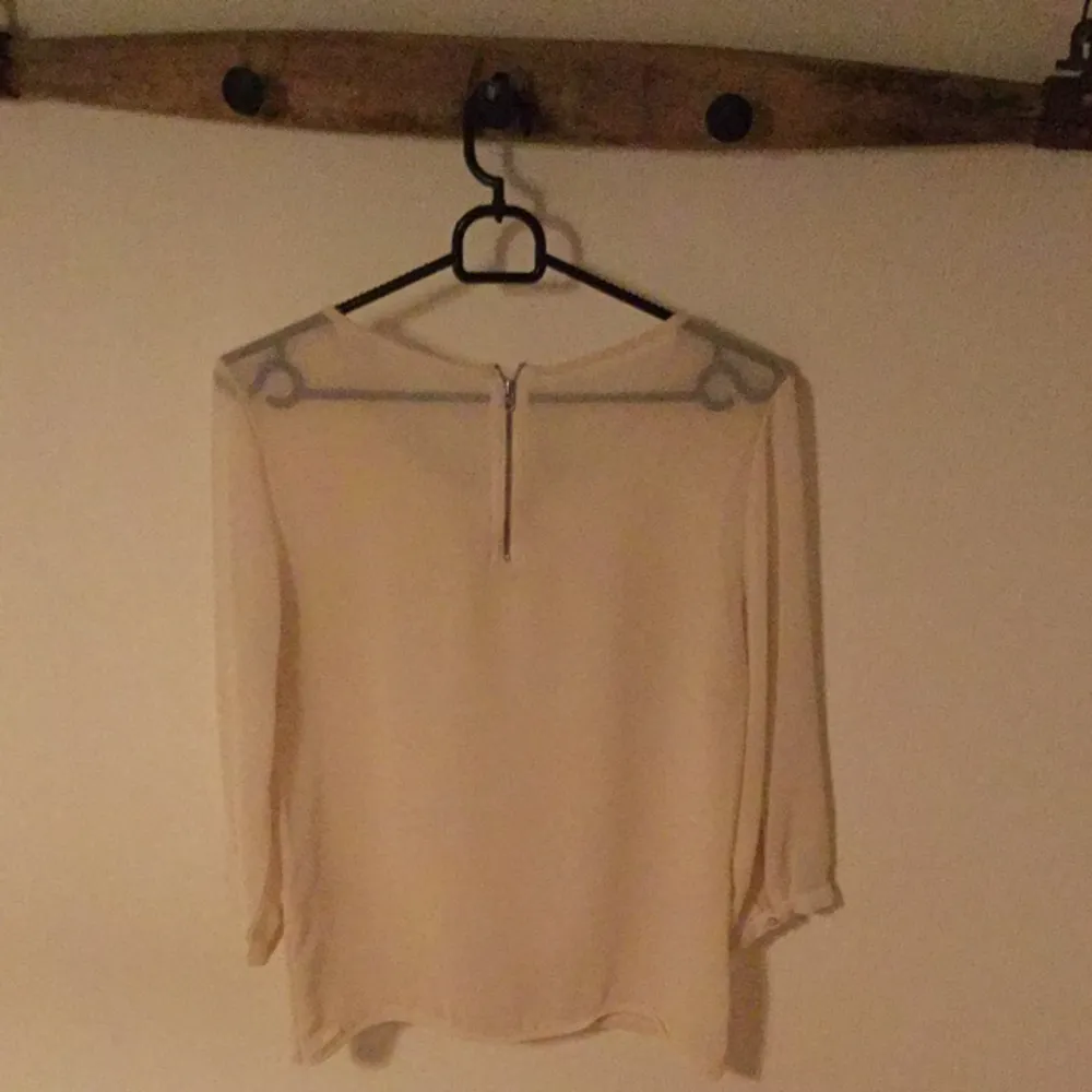 Cremefärgad bluse med transparent rygg
St S
Färg: Créme
Skick: inga synliga fel. Blusar.