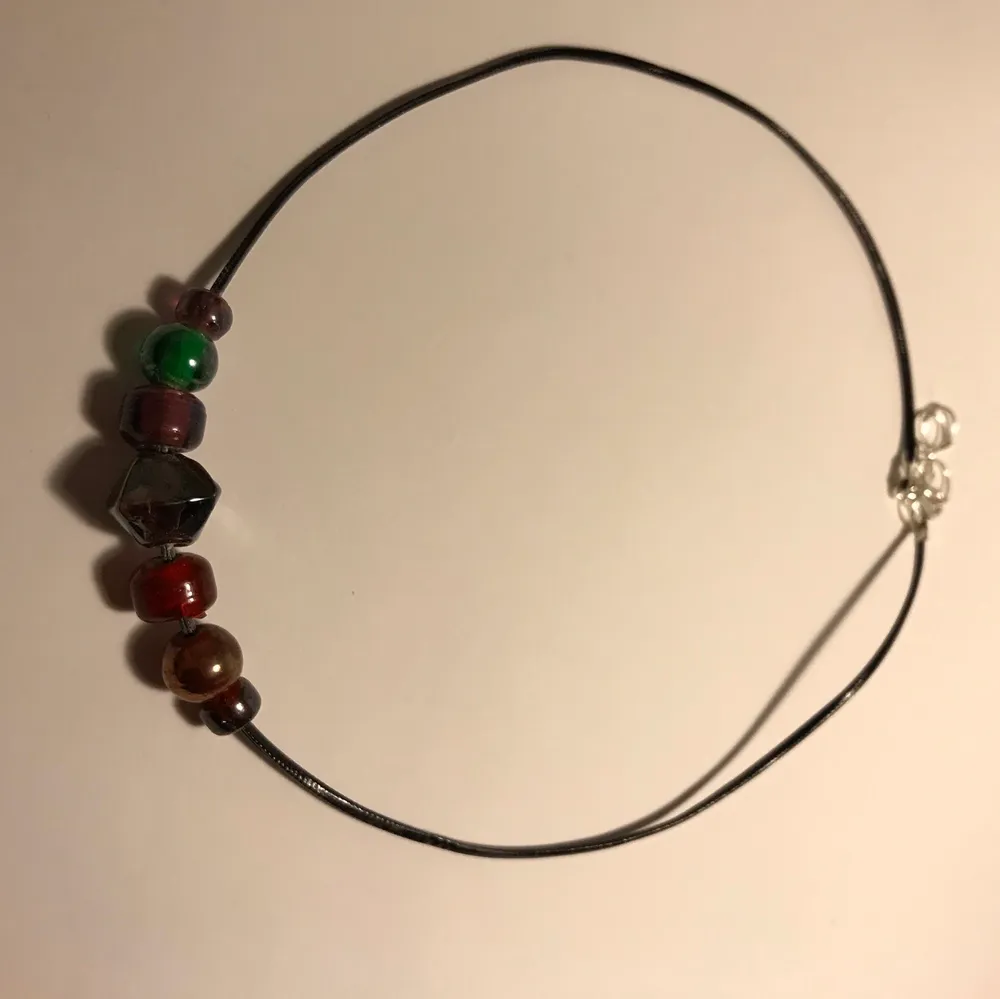 Ett svart halsband med olika pärlor/stenar i olika färger:)). Accessoarer.