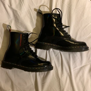 Dr. Martens - Jag säljer nu mina jättesnygga knappt använda docs i lack, som man ser på bilderna så glänser skorna i lite olika färger vilket är skit fint och originellt, skorna är i färgen black ”rainbow”. Originalpris ligger på ca 2000kr. Vid fler frågor så är det bara att skriva, skickar gärna fler bilder vid intresse!❤️