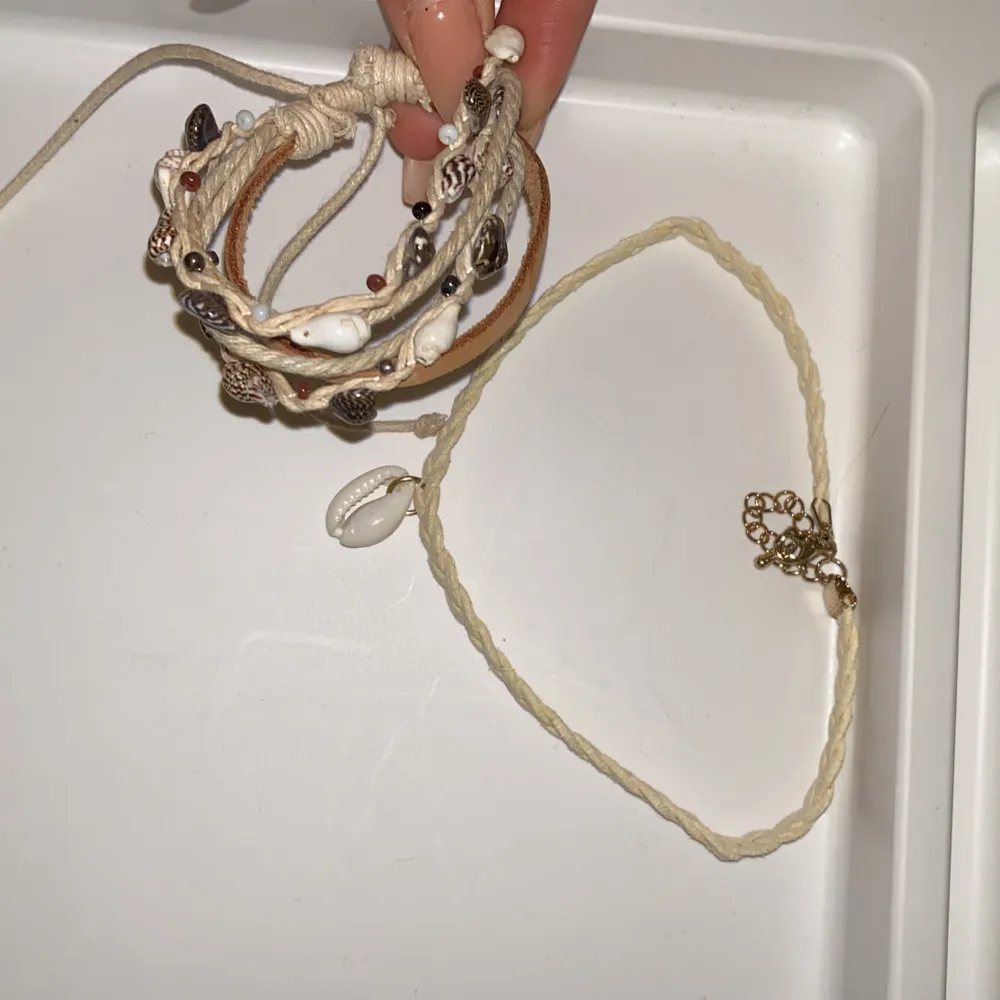 Smyckes sätt ett armband och ett halsband som matchar varsnades jätte fint, båda är handgjorda har snäckor flätade och är i färgen vit, bege, brun. . Accessoarer.