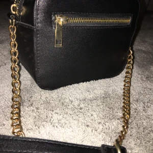 En söt handväska  - En söt handväska med ögon, det medföljer en liten tofs😃supersnygga gulddetaljer, nästan ny. Köpt på glitter för några år sen men då den inte kommer till användning säljer jag den☺️köptes för va 300-400kr mitt pris 150kr. Ryms mer i den en vad man tror