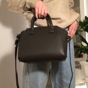 Väska - Väska från Mango som aldrig är använd. Går både att hålla i handen samt ha över axeln. Frakt ingår inte