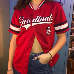 Röd collegetröja  - Röd collegetröja, perfekt att även ha över andra plagg. Blå och vita detaljer. Fint skick och skönt material. Sparsamt använd. Storlek L. 