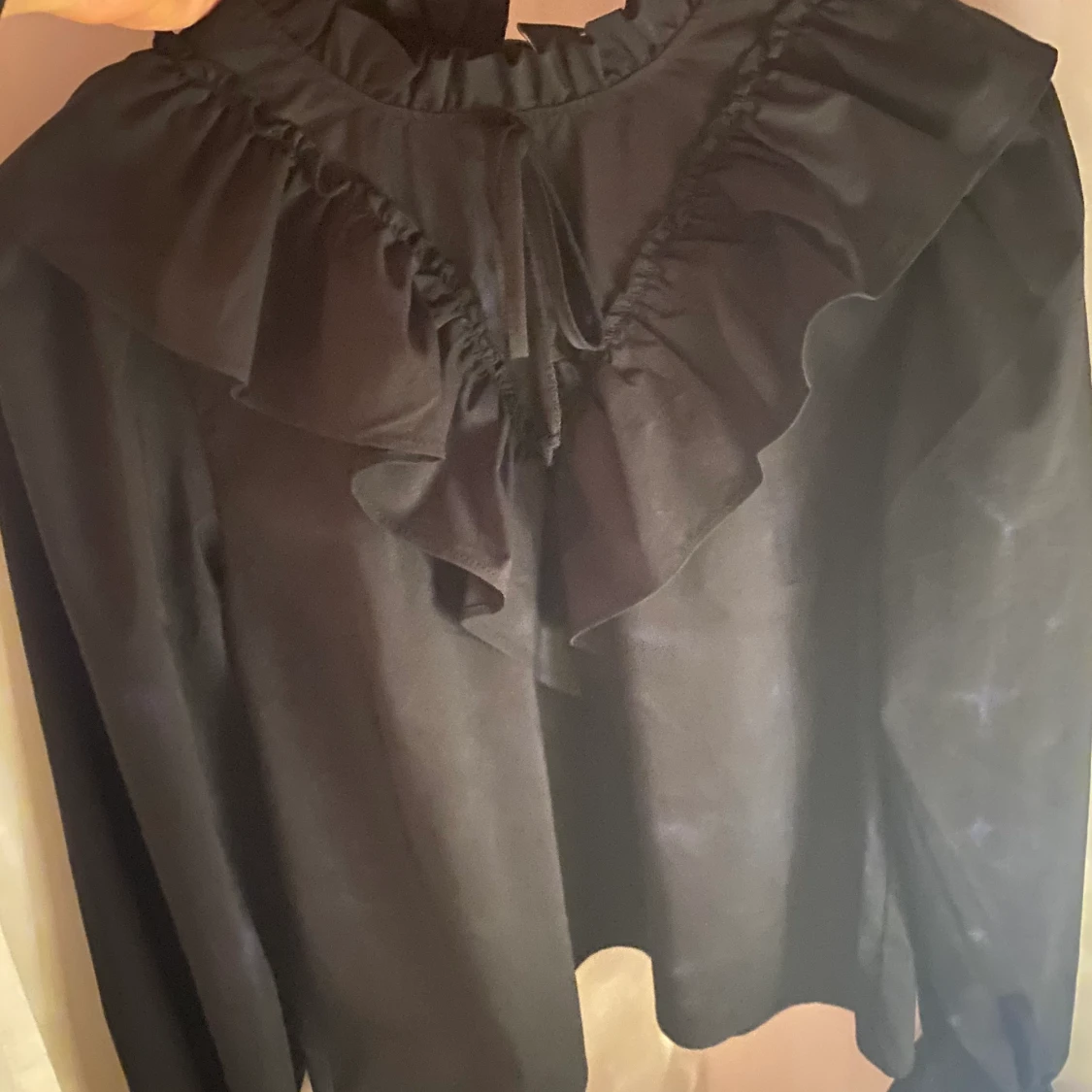 Svart blus med volanger S/36