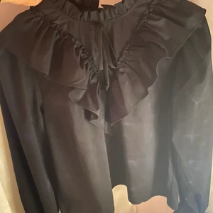 Svart blus med volanger S/36 - Jättefin blus från ginatricot. Den är helt oanvänd och ej testad. Säljs då den ej används. Köpt för 430:-. Skriv vid frågor😚
