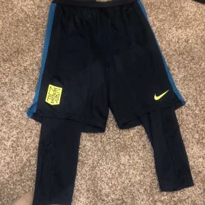 Nike träningsbyxor med tights och shorts - Nike byxa 2 i 1 byxa. Passar nog xs i dam annars är det barn storlek.