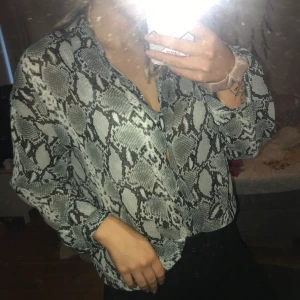Ormskinnsblus från Bikbok - Säljer denna blus/skjorta från BIKBOK då den inte kommit till någon användning. Kan mötas upp, vid frakt står köparen för kostnaden.