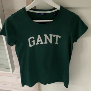 Gant t-shirt strl XS - Grön gant t-shirt. Mycket fint skick, använts någon enstaka gång. Strl XS, passar folk mellan 160-175 skulle jag säga. Hör gärna av dig vid intresse, pris kan diskuteras!