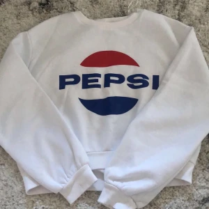 Vit pepsi sweatshirt  - En vit pepsi sweatshirt från H&M. Original pris är 199kr. Säljer för 110 inkl frakt. Inga smutsfläckar! Den är kort, till magen ungefär. 