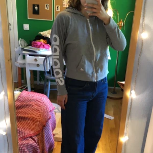 Adidaströja  - Grå huvtröja från Adidas. Flowiga ärmar och kort fit, så passar perfekt till högmidjade byxor. Prickig insida av luvan. Strl S 🌸 Kan mötas eller leverera