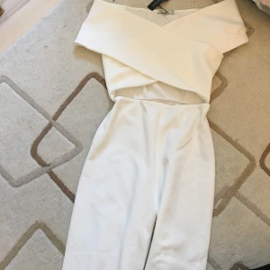 NLY ONE cross shoulder jumpsuit vit - Vit jumpsuit från Nelly som sitter som en smäck. I strl XS. Aldrig använd. 