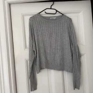 Grå stickad tröja  - Grå stickad tröja med hål i mönstret