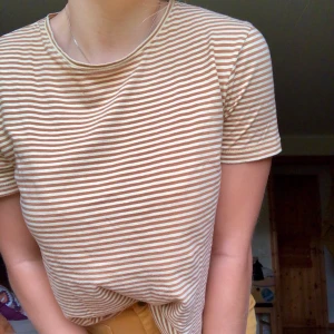 Randig T-shirt - Enkel senapsgul/brun-randig T-shirt. Använd ett fåtal gånger, fint skick. 